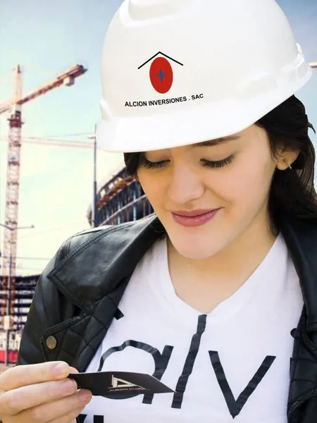 Integrante del equipo Alcion Inversiones en una obra, con casco de la estrella Alcion y grúa al fondo